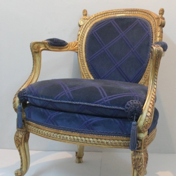 Sillon estilo Luis XV. - Madera tallada y dorada al agua con policromia. Tapizado en terciopelo con dibujo azul.