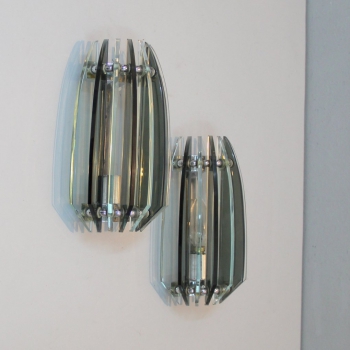Par de lámparas de pared en metal cromado y vidrio, alternando entre el cristal gris y claro. 
Casquillo E14.