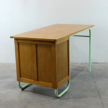 Fabricado en madera de haya y estructura tubular en hierro lacado en verde. Tiene 4 cajones muy grandes. Es una mesa muy estable.