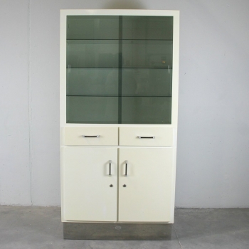 Mueble de chapa industrial. - Metal lacado en blanco- beige y puertas en cristales tintados.
Tiene 3 baldas de cristal y una de chapa en su interior.