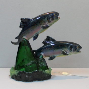 Realizada por el escultor español Santiago Rodrigues Bonome (1901-1995). Sus esculturas están caracterizadas por un gran realismo.
Cristal prensado en verde  y cerámica esmaltada.
Firmada